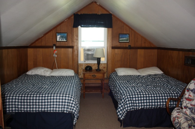 Upstairs bedroom with two beds in navy gingham