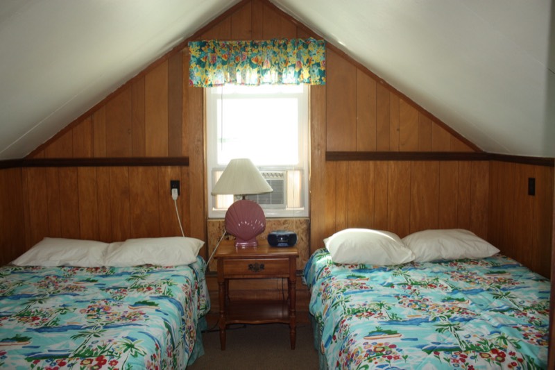 Upstairs bedroom with two beds in tropical prints