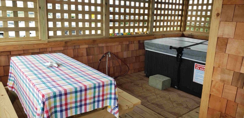 Screened porch with rocking chairs, a glider bench, and a view to the ocean