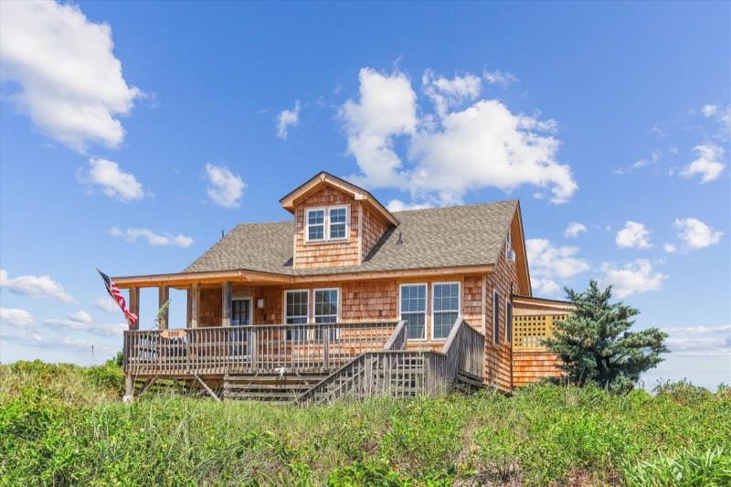 Cedar-shake front elevation of the cottage with wraparound deck