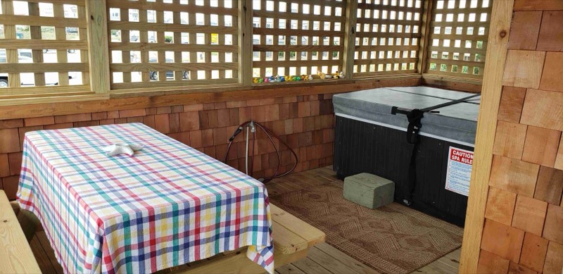 Hot tub on the lattice-screened porch with a row of rubber ducks on the sill