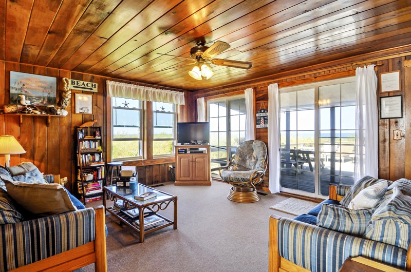 Living room with pine ceilings, ceiling fan, and ocean views